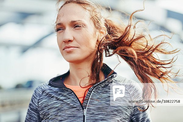 Porträt einer Läuferin mit Flyaway-Haaren auf dem Stadtsteg