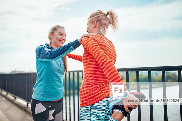 Zwei Läuferinnen beim gemeinsamen Aufwärmen auf dem Steg
