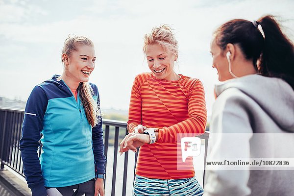 Drei Läuferinnen koordinieren die Zeit auf der Stadtbrücke