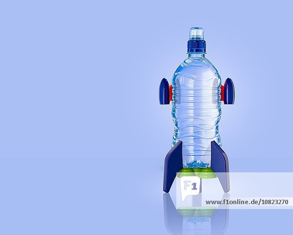 Stehende Wasserflaschenrakete mit blauem Hintergrund