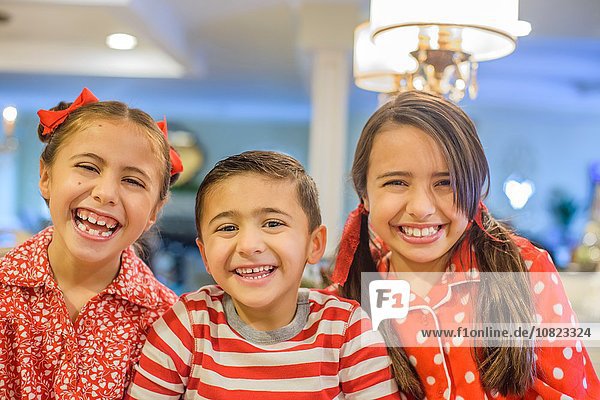 Portrait of children wearing pyjamas looking at camera smiling