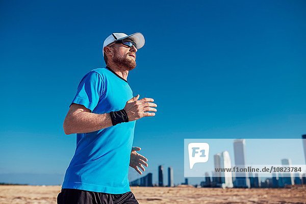Tiefblick auf einen erwachsenen Mann  der durch Wolkenkratzer läuft  Dubai  Vereinigte Arabische Emirate