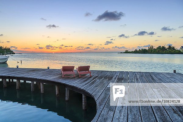 Zwei Liegestühle an der Uferpromenade bei Sonnenuntergang  St. Georges Caye  Belize  Zentralamerika