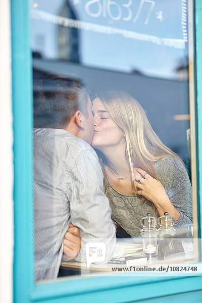Romantisches junges Paar im Cafe  das sich küsst.