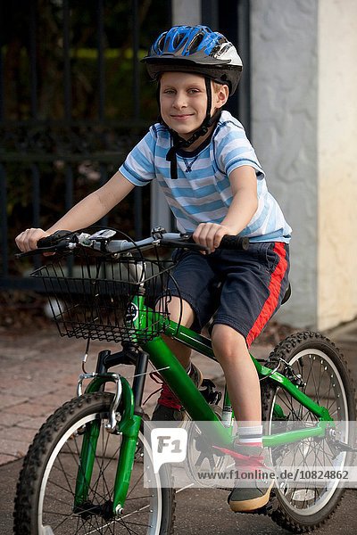 Junge mit Fahrrad auf dem Bürgersteig