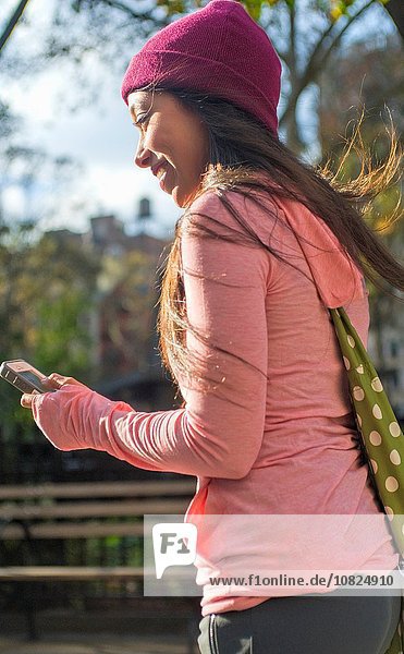 Young woman using smartphone in park