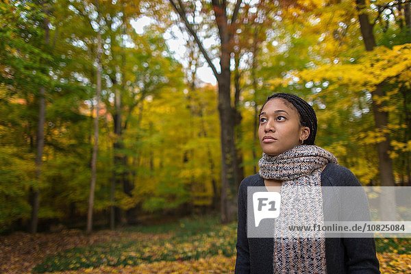 Mittlere erwachsene Frau beim Spaziergang im Herbstwald