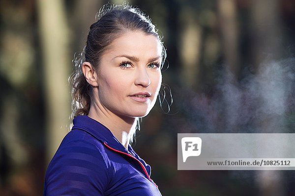 Portrait of young woman looking at camera  condensation from breath