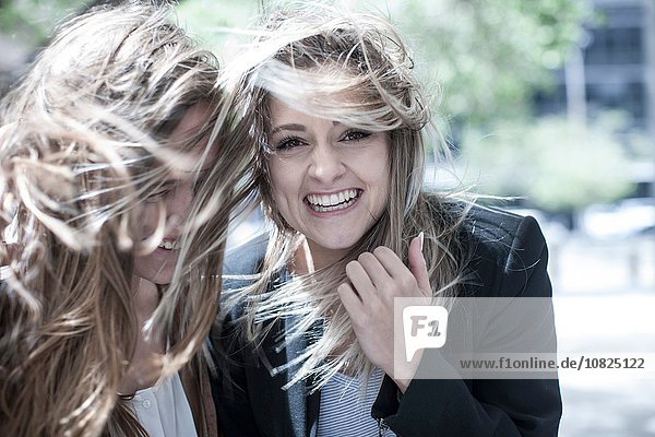 Portrait of young woman and teenage girl with flyaway hair in city