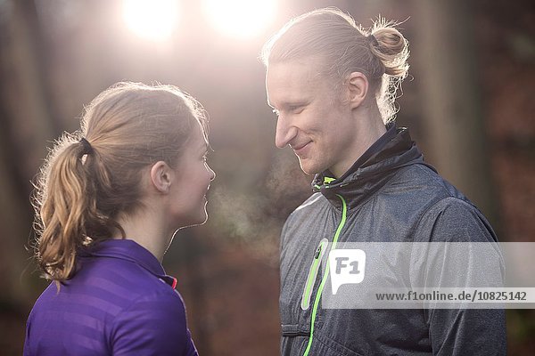 Couple wearing sports clothing face to face smiling