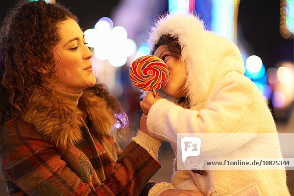 Mother and daughter enjoying lollipop