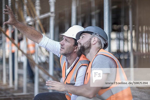Bauleiter und Bauherr bei der Suche nach Stahlstäben auf der Baustelle