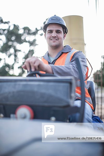 Portrait of young male steamroller driver on construction site