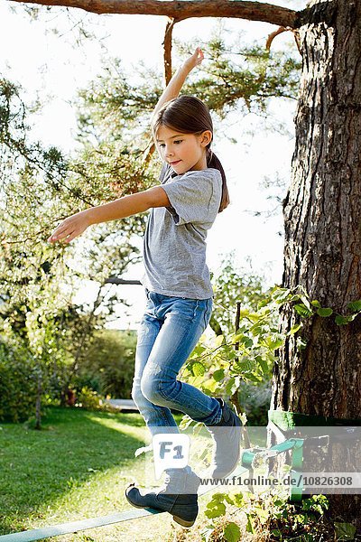 Girl balancing on rope on tree