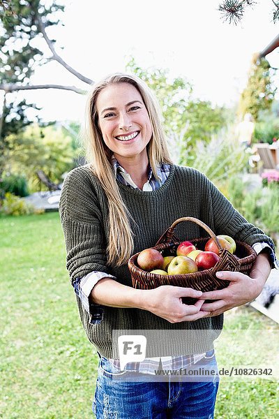Mittlere erwachsene Frau mit Apfelkorb  Portrait