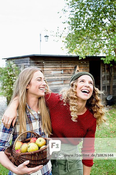 Zwei Frauen im Garten mit Apfelkorb  lachend