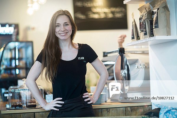 Porträt einer jungen Kellnerin hinter der Küchentheke im Cafe