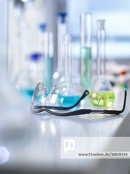 Schutzbrille auf Labortisch  wissenschaftliche Ausstattung im Hintergrund