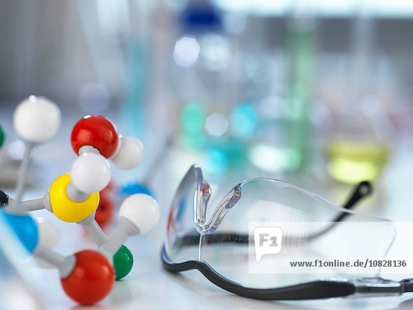 Schutzbrille und molekulares Modell auf dem Labortisch