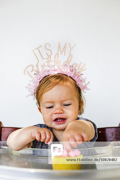 Kaukasisches kleines Mädchen isst Geburtstagstörtchen