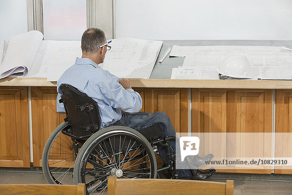 Kaukasischer Architekt im Rollstuhl im Gespräch im Büro