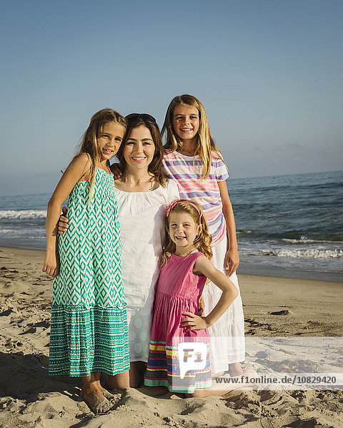 Kaukasische Mutter und Töchter lächelnd am Strand