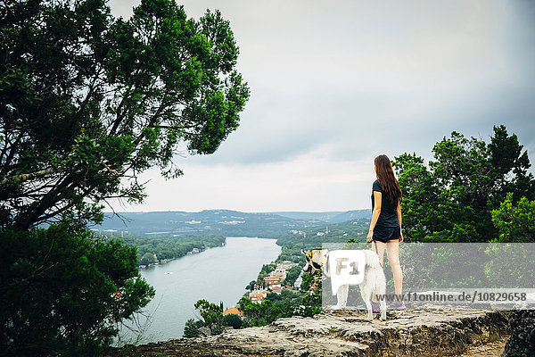 Kaukasische Frau und Hund bewundern landschaftliche Aussicht