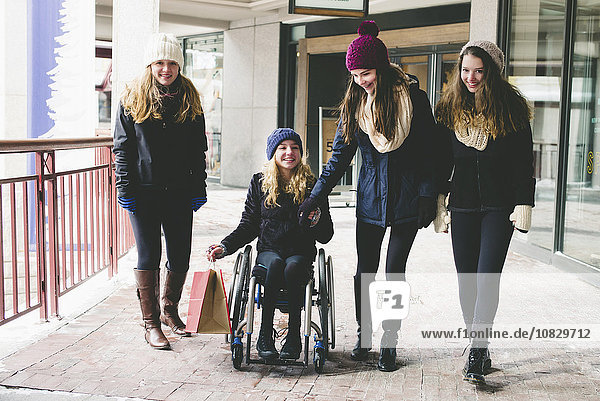 Mädchen zu Fuß und im Rollstuhl auf dem Bürgersteig