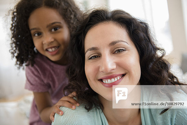 Mutter und Tochter lächelnd in einem Haus