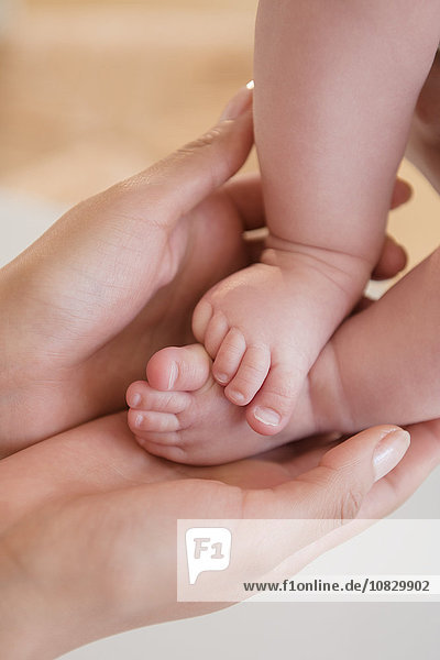 Nahaufnahme der Mutter  die die nackten Füße des Babys hält