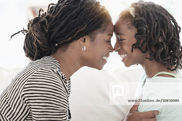 Schwarze Mutter und Tochter berühren die Nasen