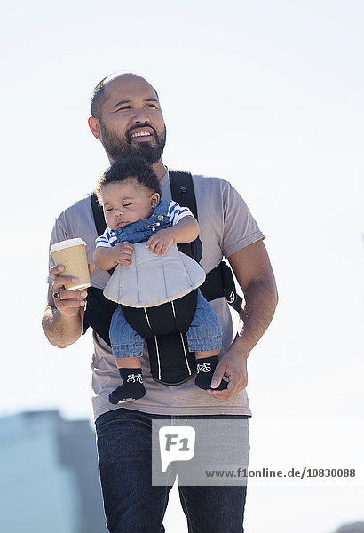 Vater trägt seinen kleinen Sohn im Freien