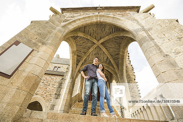 Kaukasisches Paar auf Schlossstufen stehend