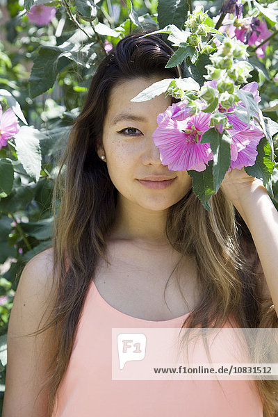 Asian woman hiding behind flower