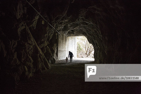 Kaukasische Mutter und Tochter gehen in einer Höhle spazieren