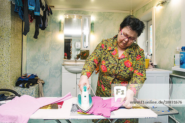 Kaukasische Frau bügelt Wäsche