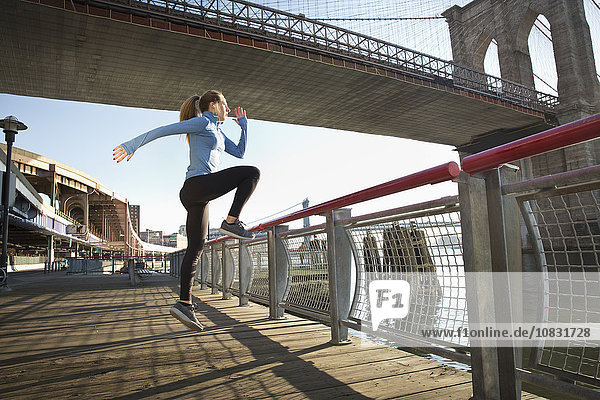 Kaukasischer Läufer beim Stretching am Wasser  New York  New York  Vereinigte Staaten