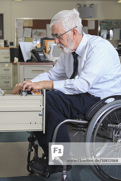 Caucasian businessman filing papers in office