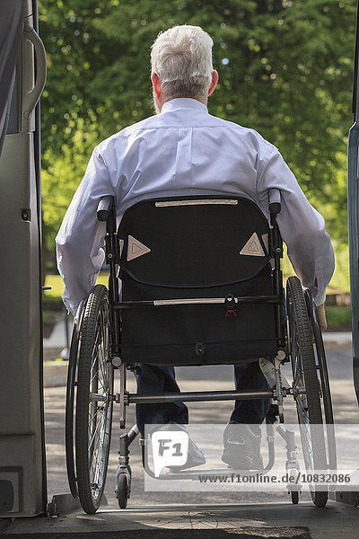 Kaukasischer Geschäftsmann im Rollstuhl beim Aussteigen aus einem Lieferwagen