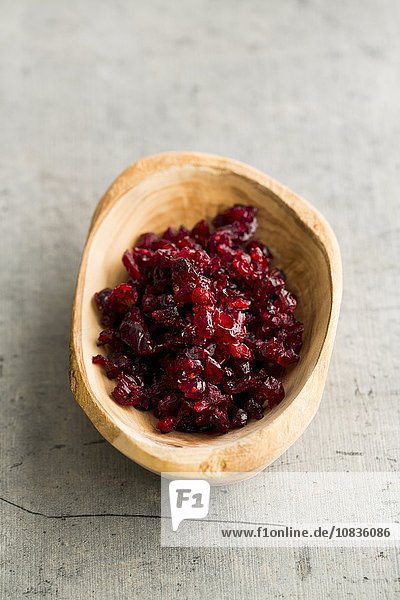Gehackte  getrocknete Cranberries in einer Holzschale