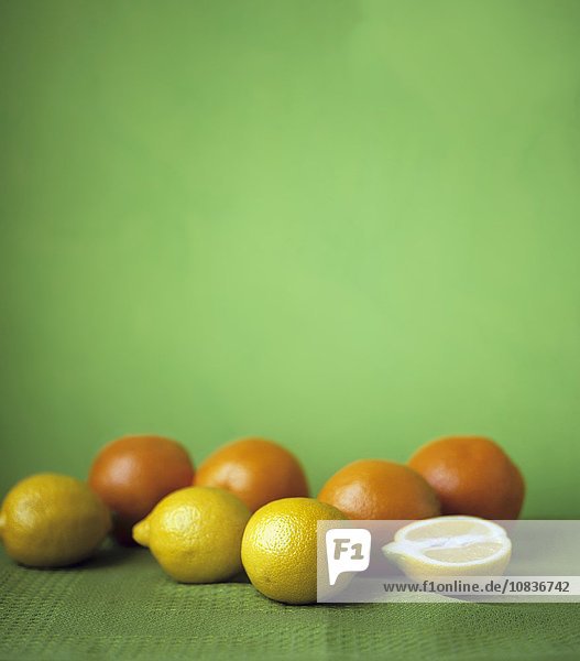 Zitronen und Orangen auf grünem Untergrund