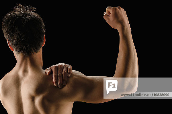Japanischer männlicher Athlet zeigt seine Muskeln