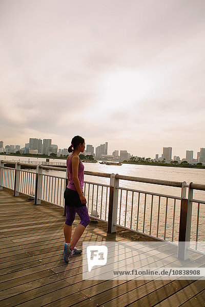 Young Japanese woman stretching before her run downtown Tokyo