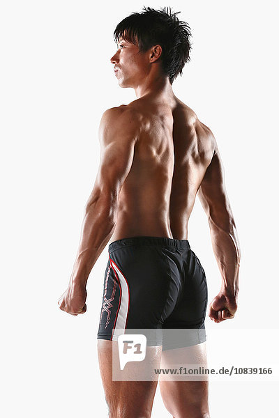 Japanischer männlicher Athlet zeigt seine Muskeln