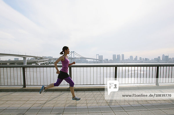 Young Japanese woman running downtown Tokyo
