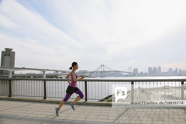 Young Japanese woman running downtown Tokyo