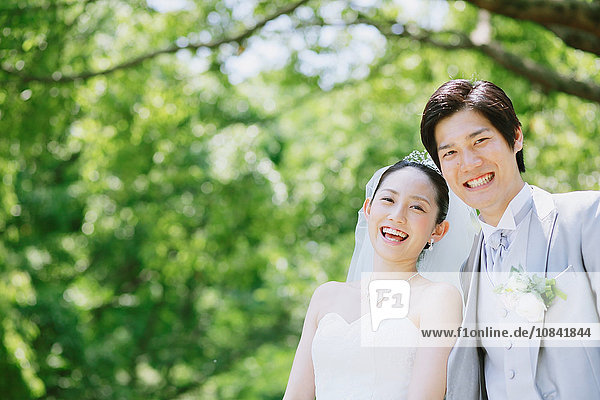 Japanese bride and groom in a city park