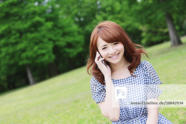 Junge attraktive japanische Frau in einem Stadtpark