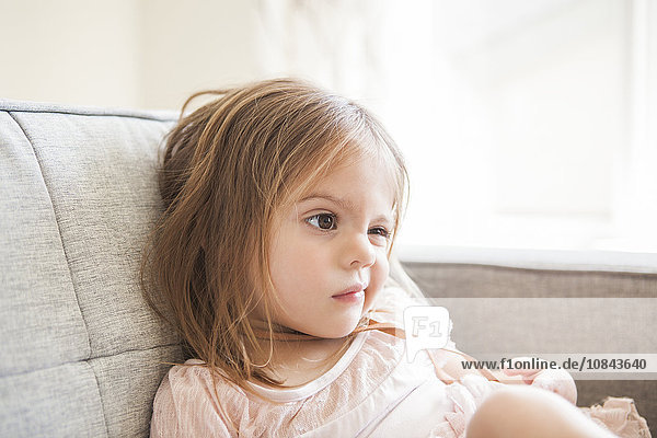 Toddler girl making a face on sofa