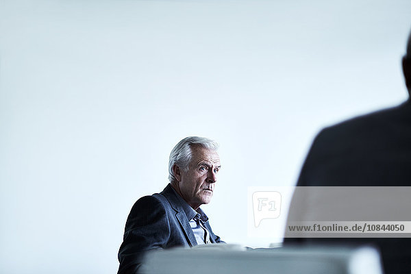 Serious senior businessman listening in meeting